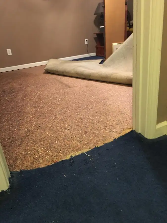 Carpet pad removal revealing water damage during Water Mitigation Services in Green Lake